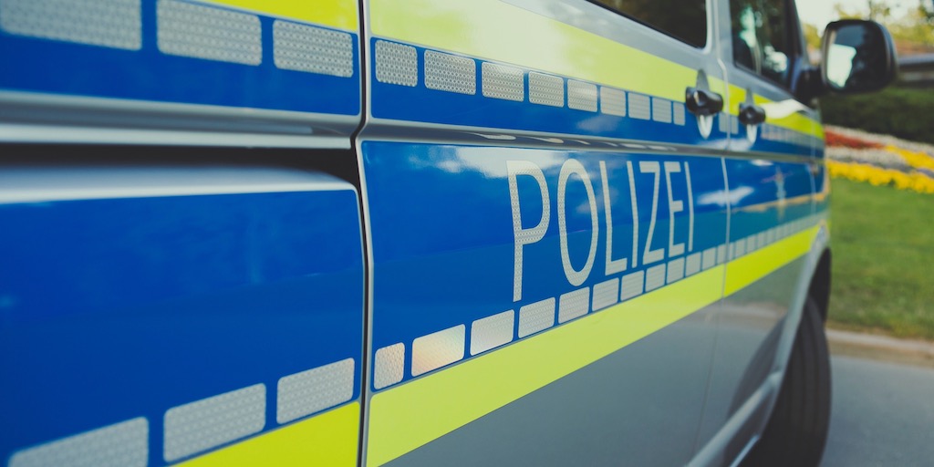 Ermittlungen am ONG Polizei Auto von der Seit mit Schriftzug "Polizei" im Vordergrund